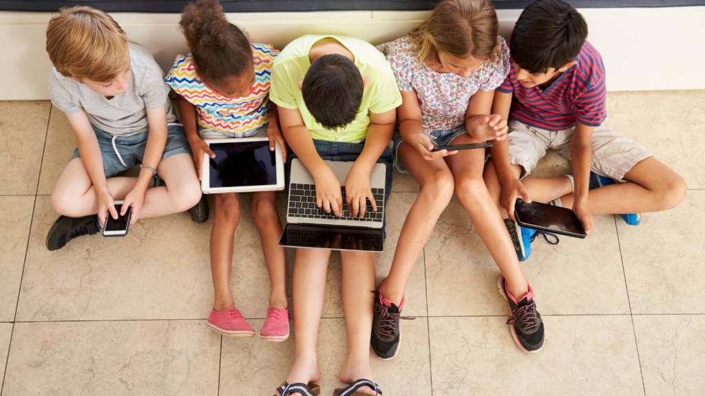 Children sitting on floor with laptops