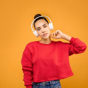 girl in read crop top sweatshirt with headphones