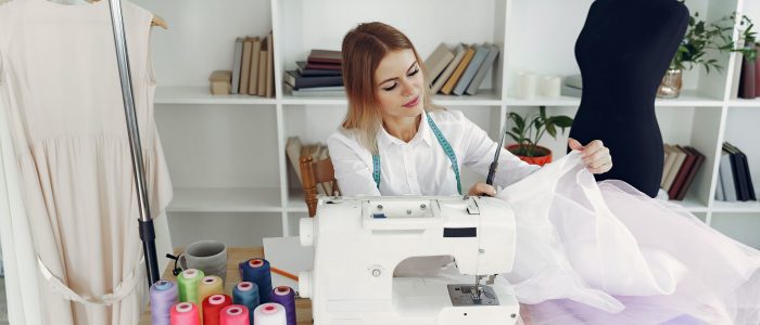 woman-in-white-blouse-sitting-on-chair-in-front-of-sewing-3984847